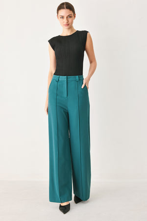 Woman wearing teal woven wide-leg  trouser pants with front closure, side pockets | FREEMARKET