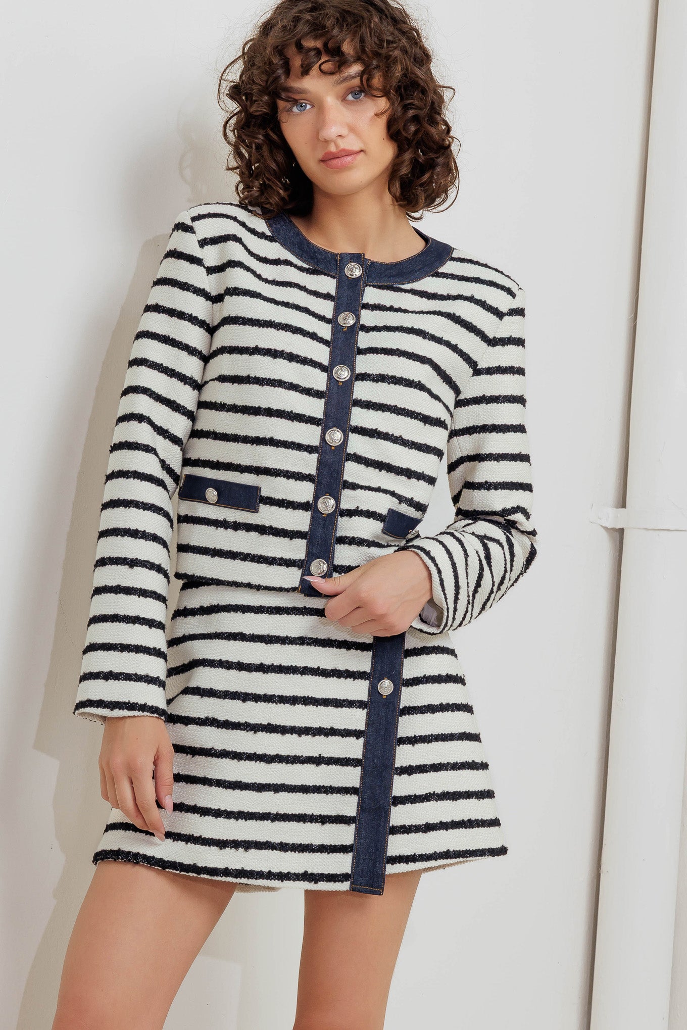 A textured striped woven skort featuring front button detail and denim trimmed edge.