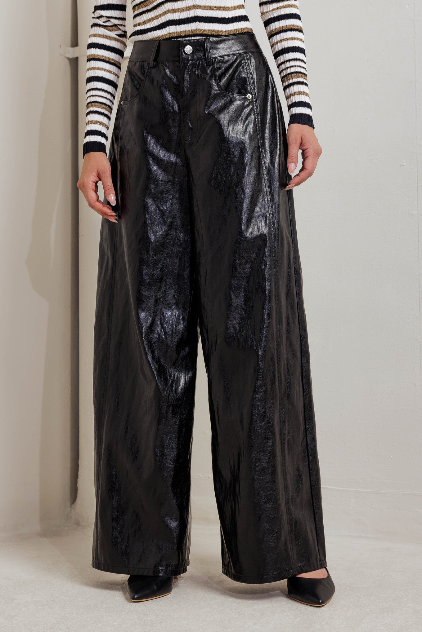 A faux leather pant with front closure, side/back pocket and wide leg