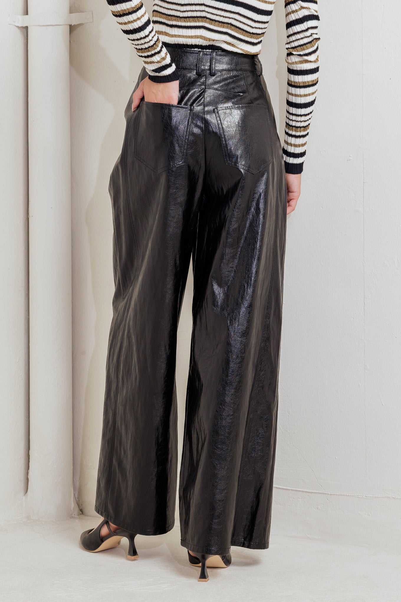 A faux leather pant with front closure, side/back pocket and wide leg