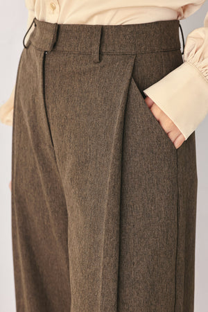 A woman wearing high-waisted, wide-leg brown trousers | FREEMARKET