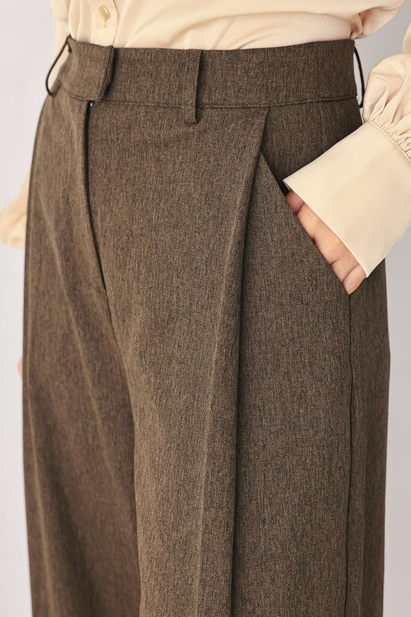 A woman wearing high-waisted, wide-leg brown trousers | FREEMARKET