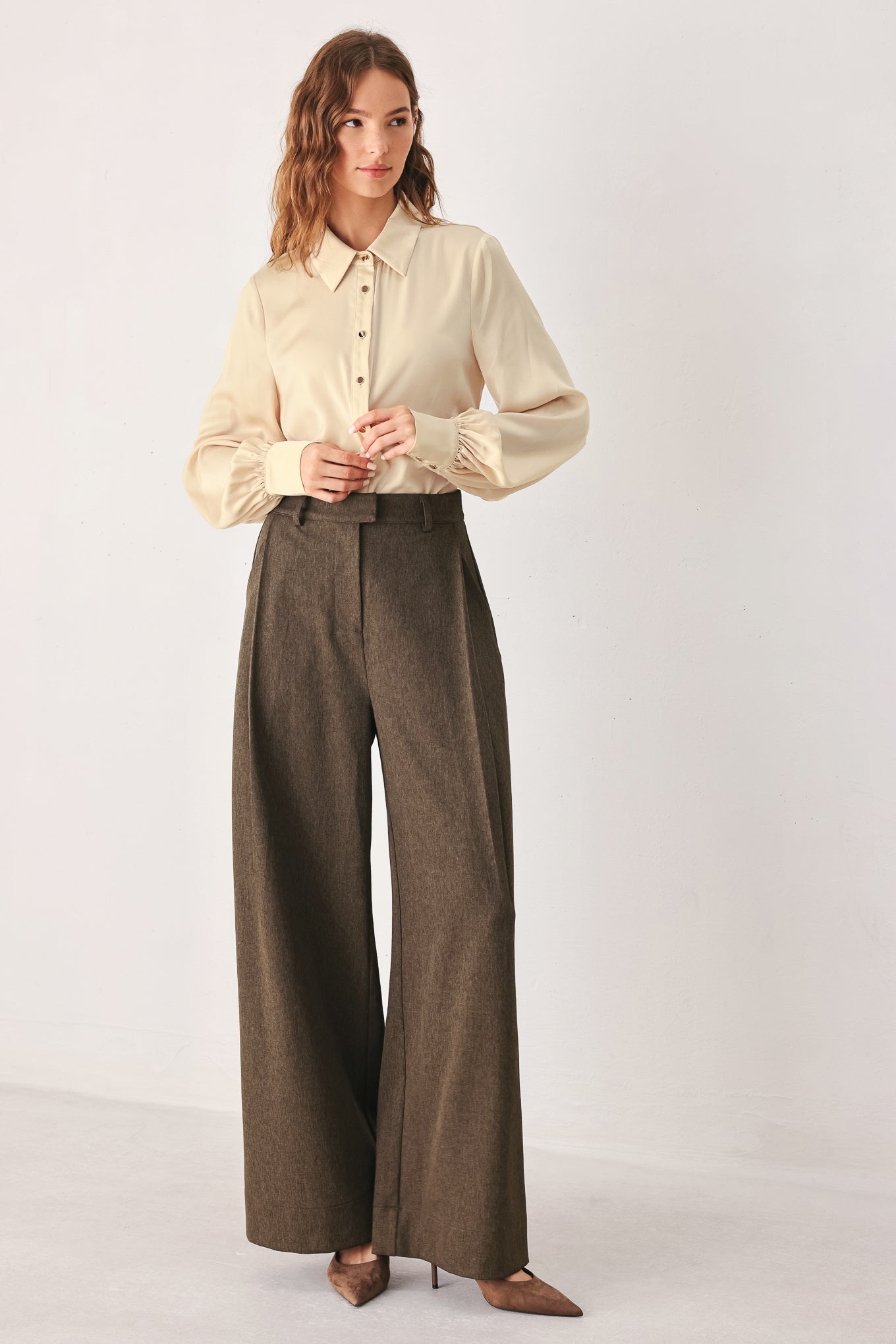 A woman wearing high-waisted, wide-leg brown trousers | FREEMARKET