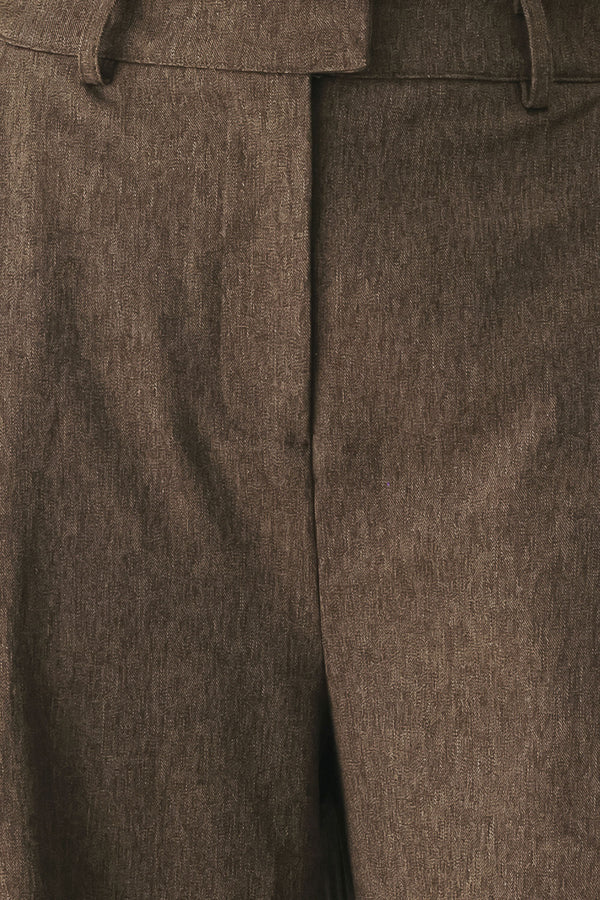 A woman wearing high-waisted, wide-leg brown trousers | FREEMARKET