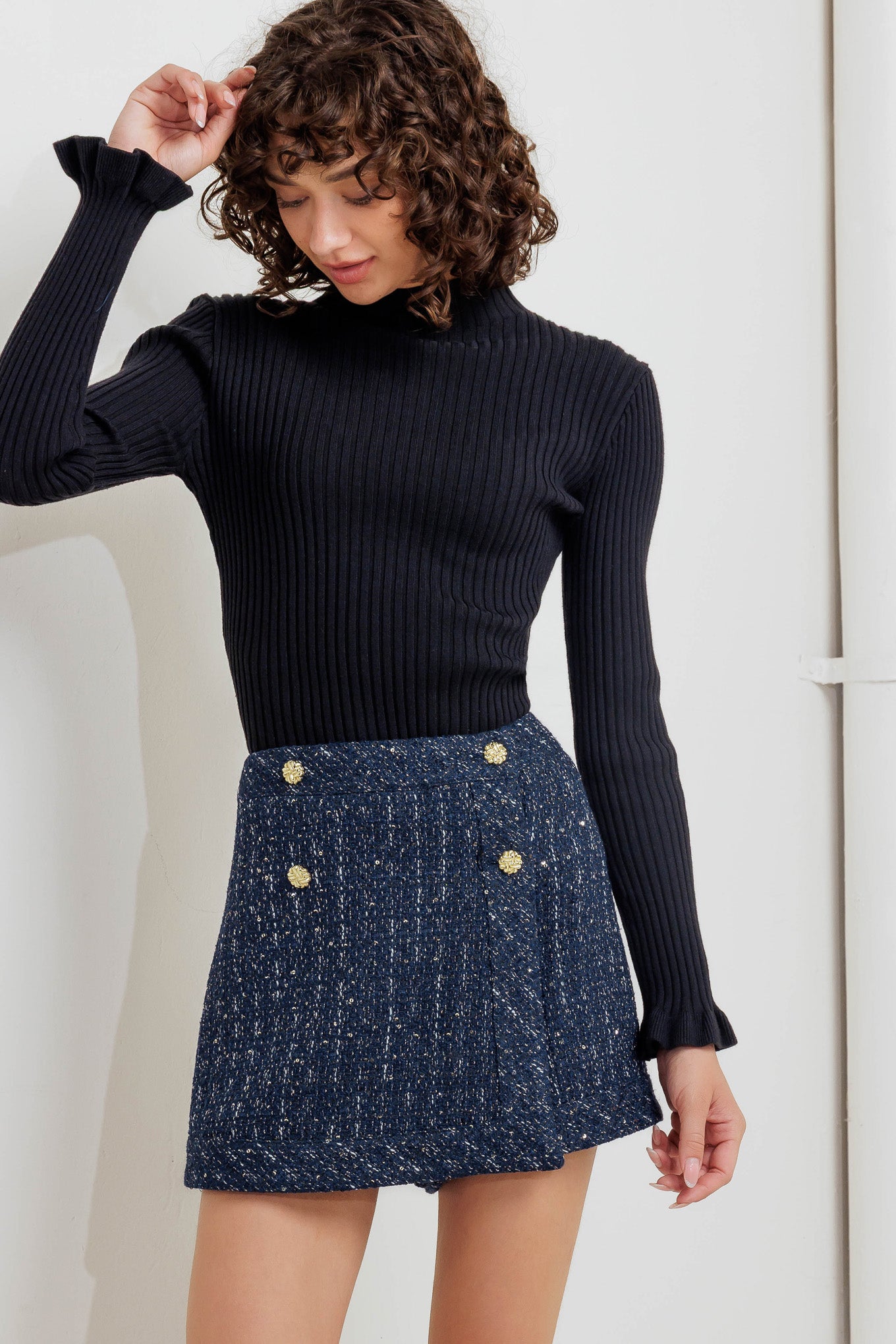 A tweed skort with front button and zipper closure. 