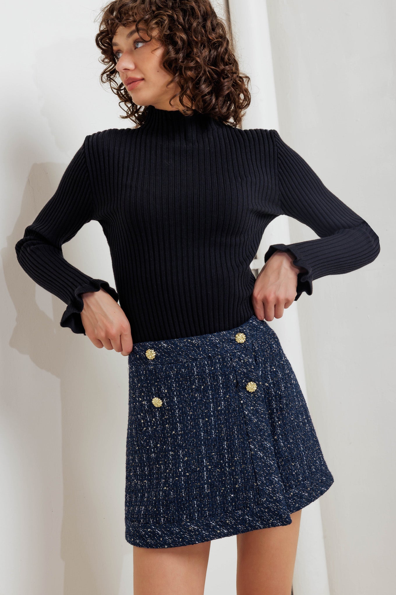 A tweed skort with front button and zipper closure. 