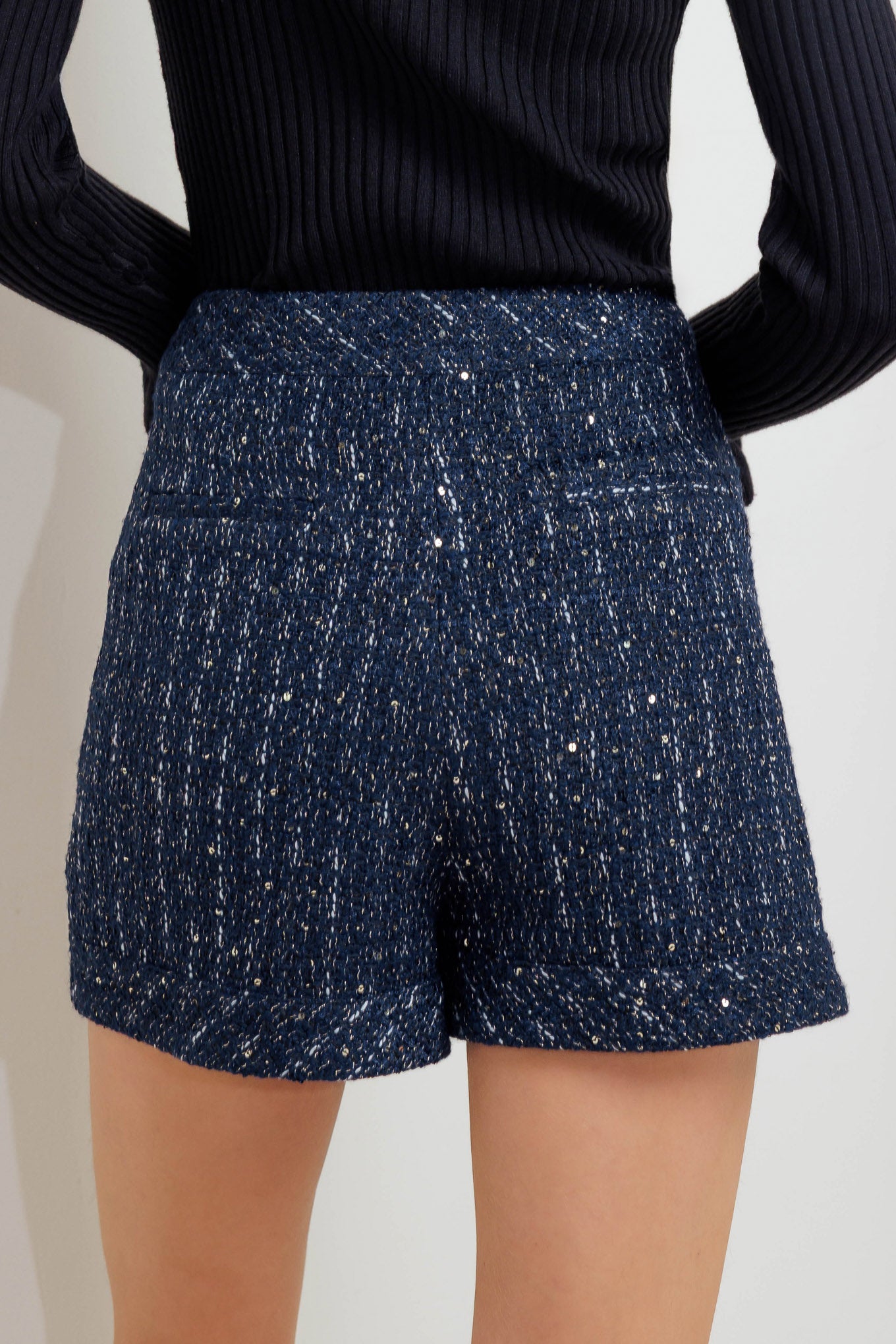 A tweed skort with front button and zipper closure. 