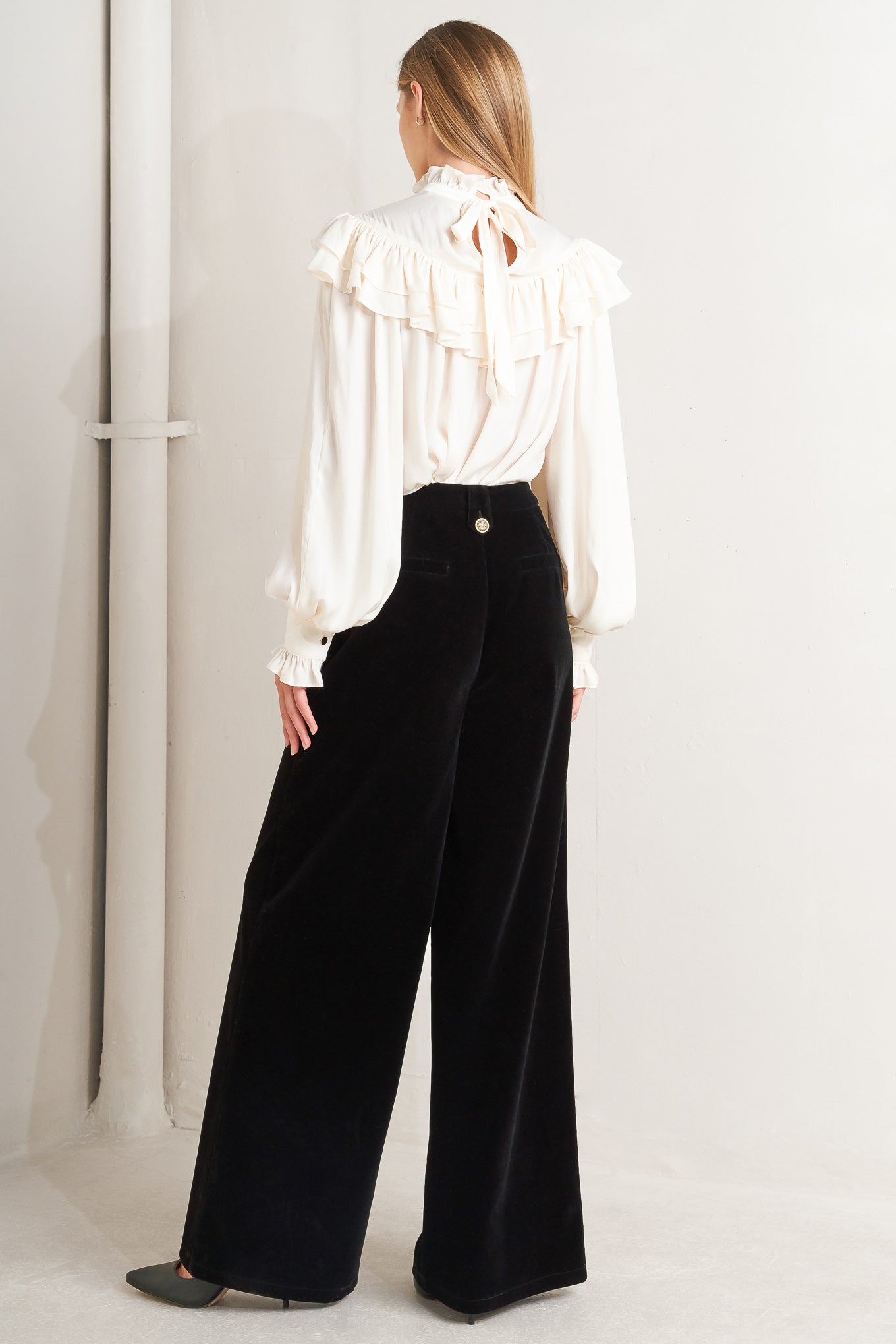A bonded velvet pant featuring front closure, side pocket with button detail and wide leg