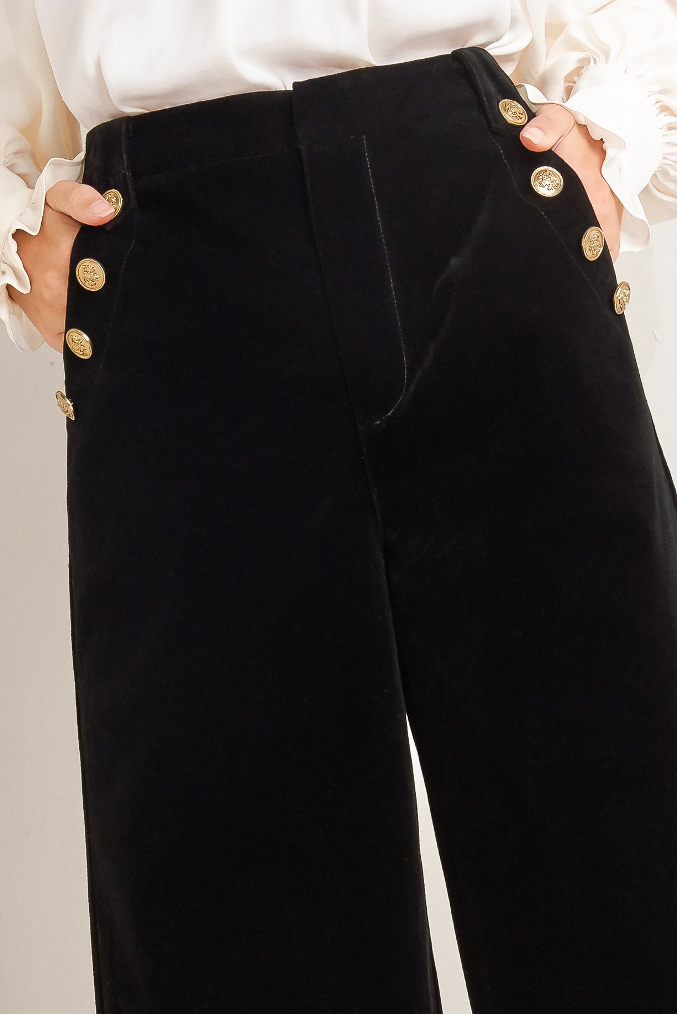 A bonded velvet pant featuring front closure, side pocket with button detail and wide leg