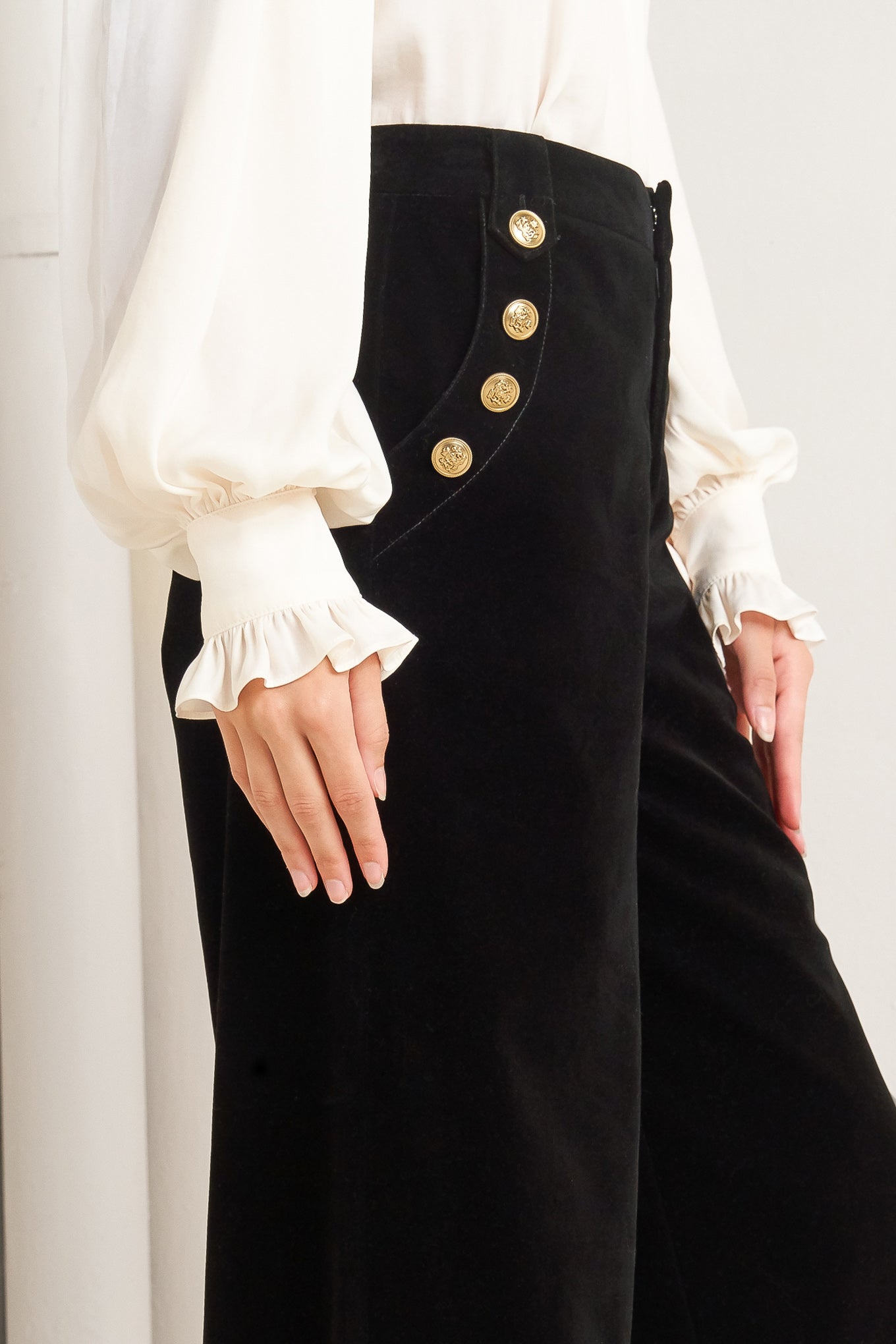 A bonded velvet pant featuring front closure, side pocket with button detail and wide leg