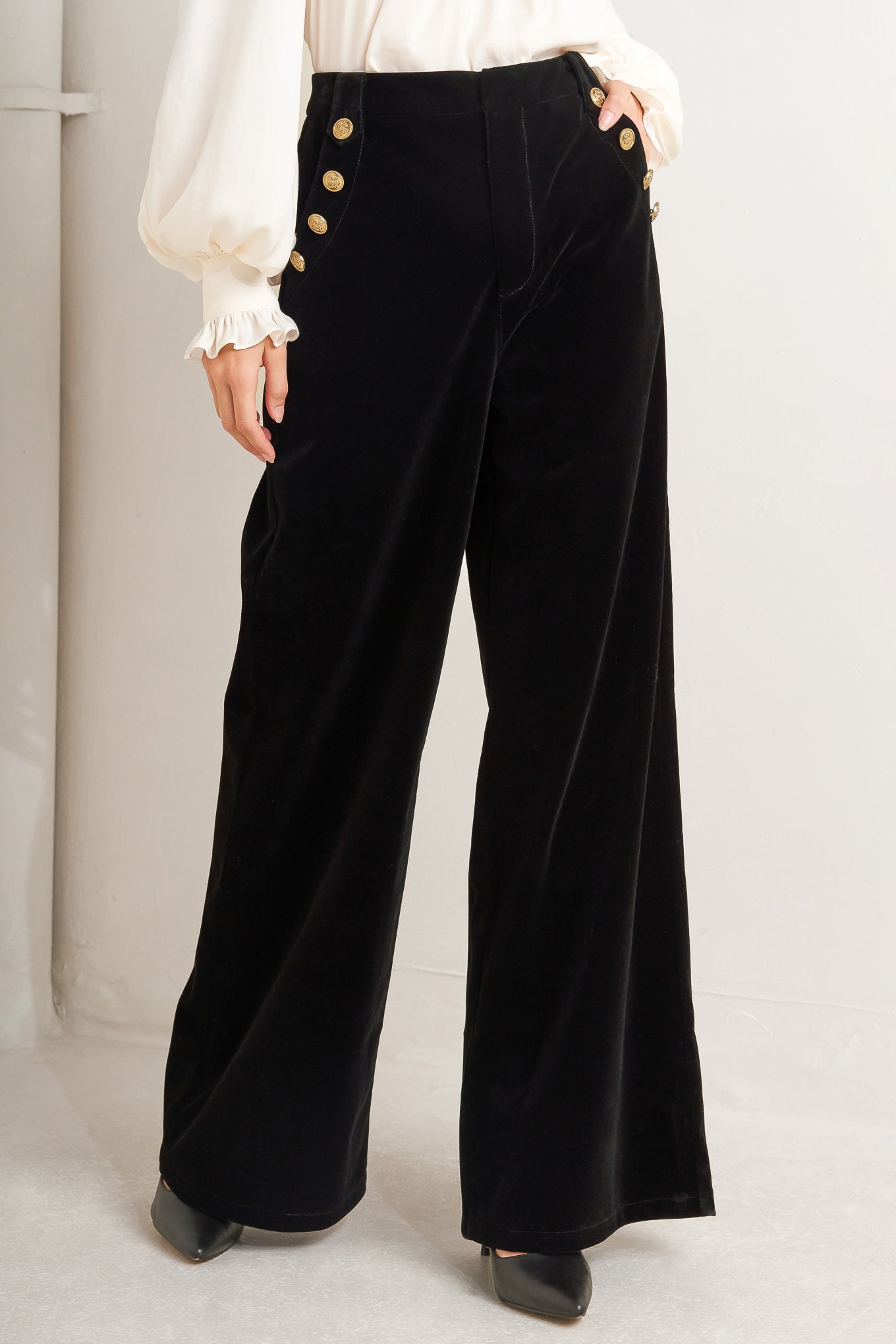 A bonded velvet pant featuring front closure, side pocket with button detail and wide leg