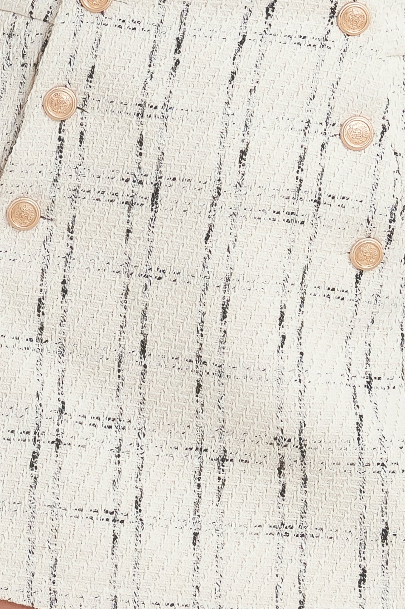 A woven tweed skort with front button closure.