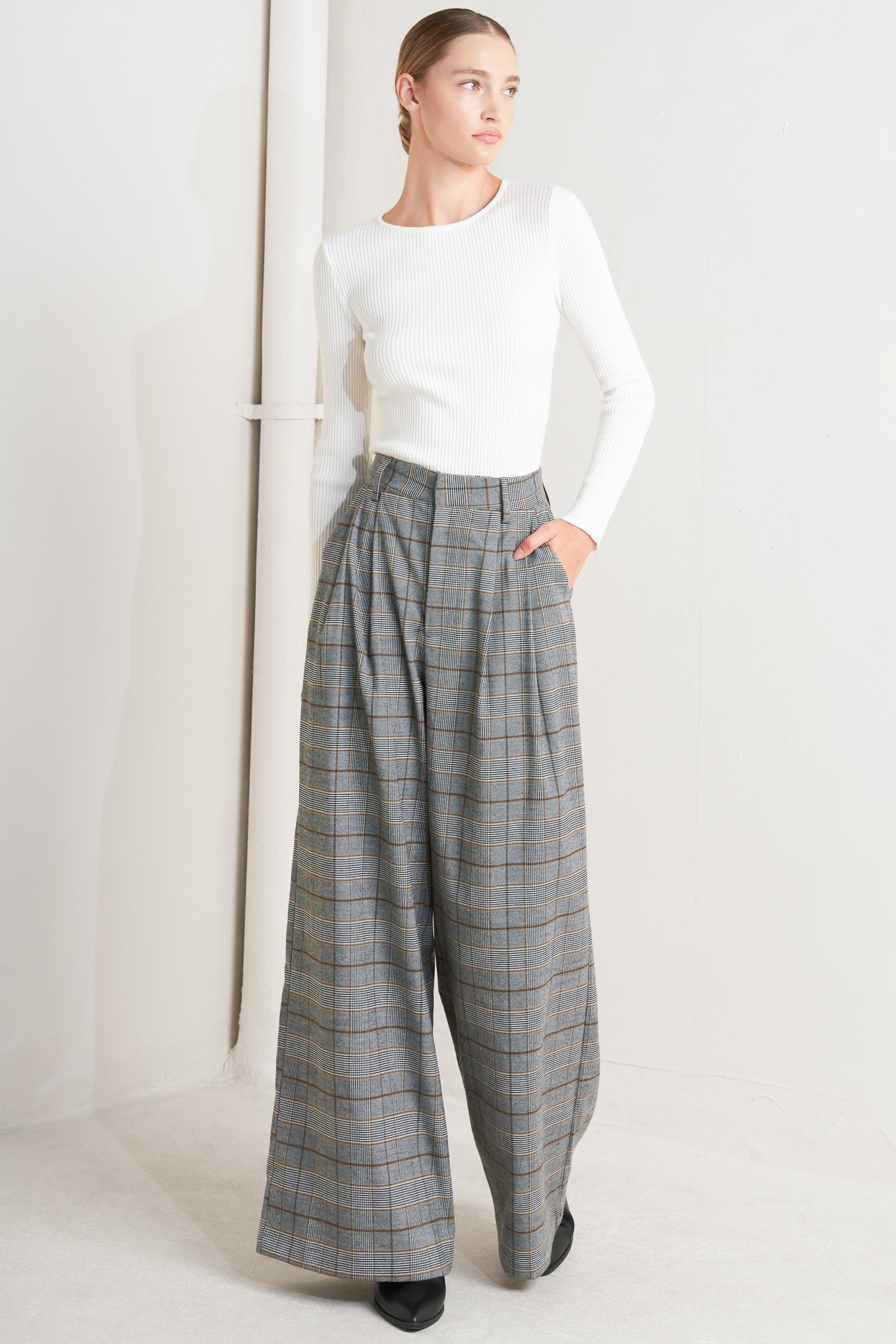 A woven plaid pant featuring front closure, side pockets and wide leg.&nbsp;