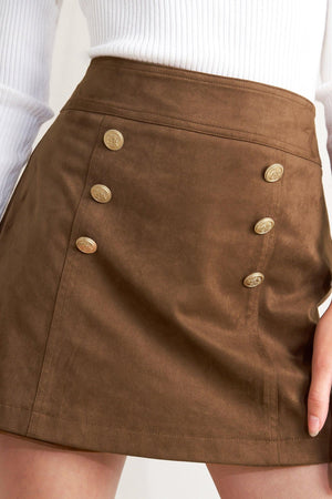 A faux suede skort with front button detail and back zipper closure.