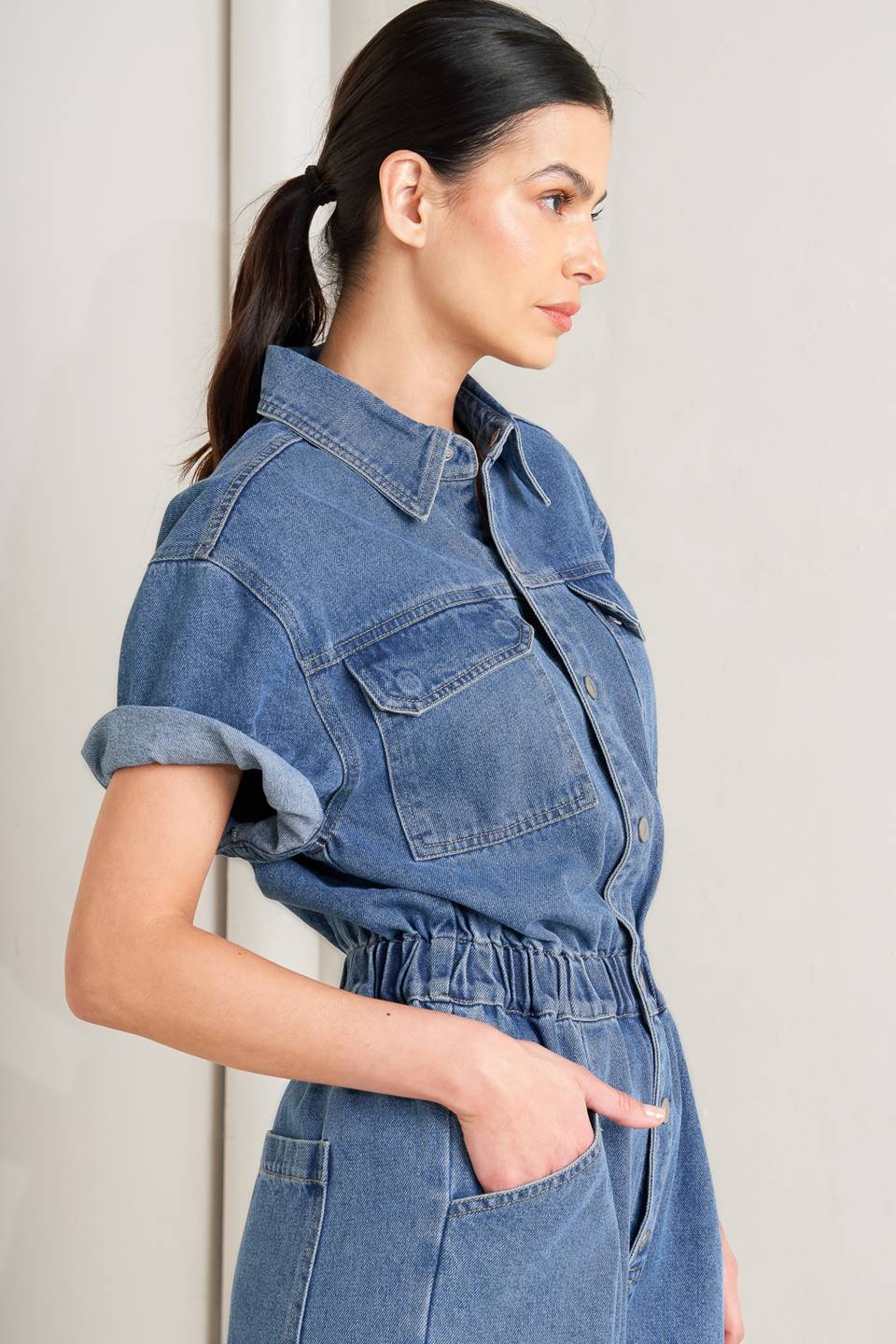 Woman wearing a denim jumpsuit against a plain background - FLYING TOMATO