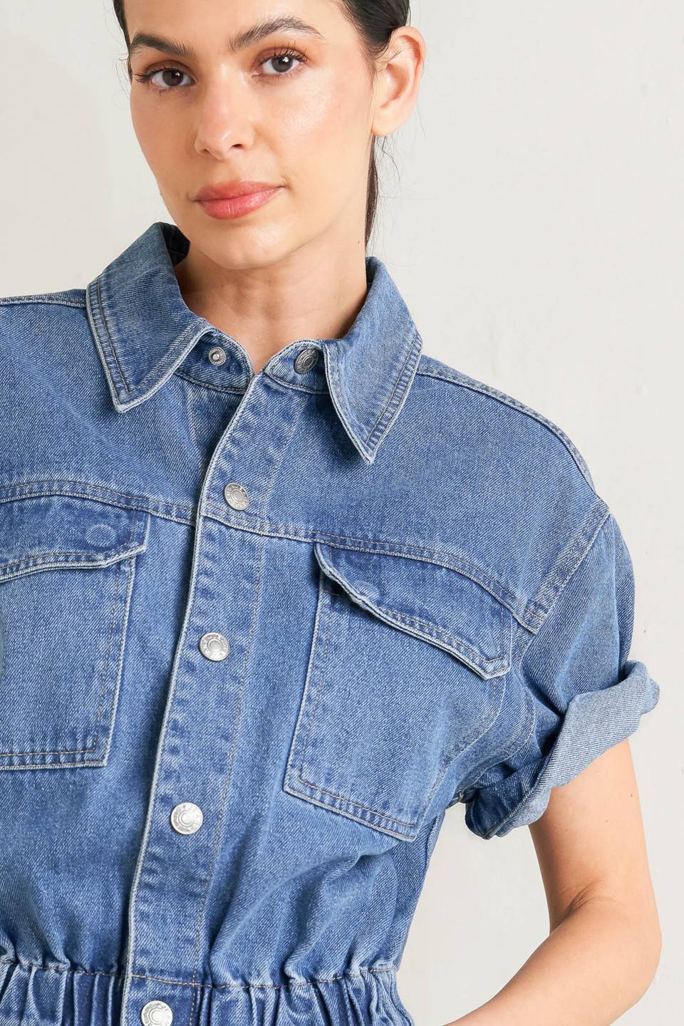 Woman wearing a denim jumpsuit against a plain background - FLYING TOMATO