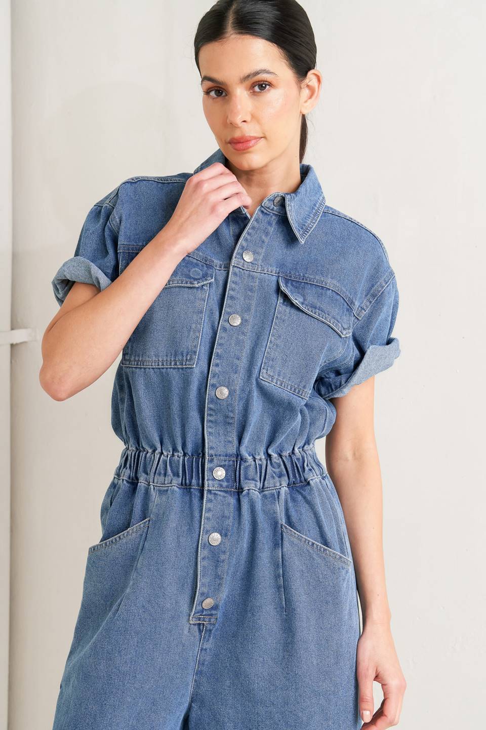 Woman wearing a denim jumpsuit against a plain background - FLYING TOMATO