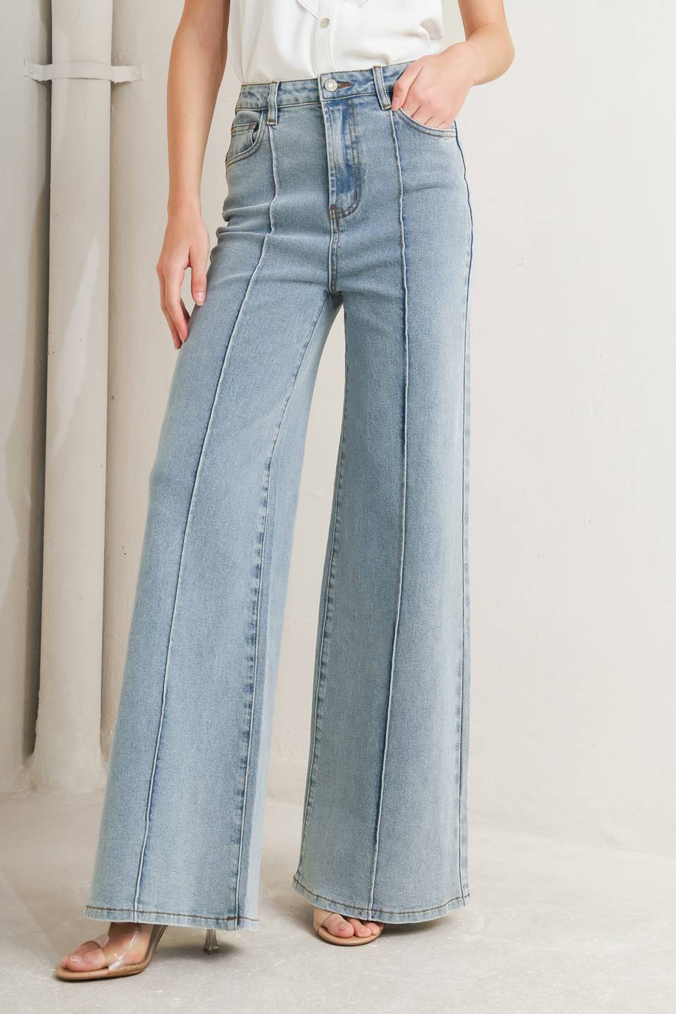 Person wearing light blue wide-leg jeans against a neutral background