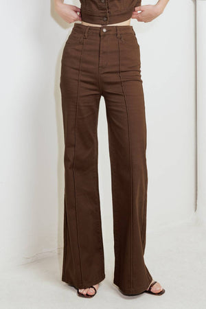 Woman wearing solid burgundy twill pants featuring front closure, front seam in the middle of each leg and pockets | FREEMARKET