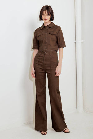 Woman wearing solid brown twill pants featuring front closure, front seam in the middle of each leg and pockets | FREEMARKET