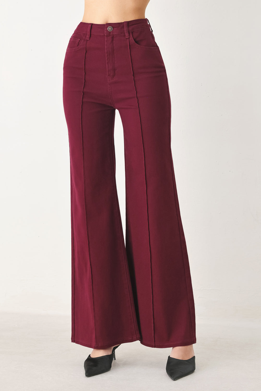 Woman wearing solid burgundy twill pants featuring front closure, front seam in the middle of each leg and pockets | FREEMARKET
