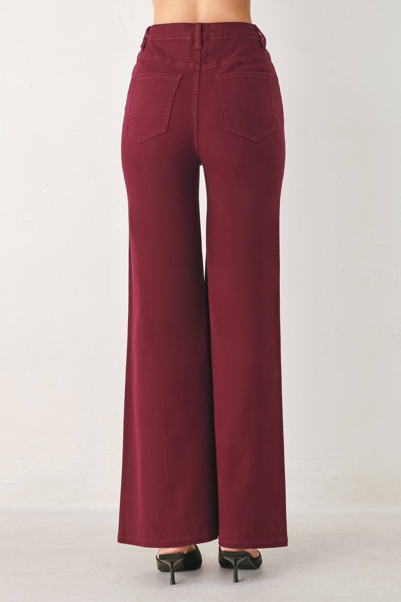 Woman wearing solid burgundy twill pants featuring front closure, front seam in the middle of each leg and pockets | FREEMARKET