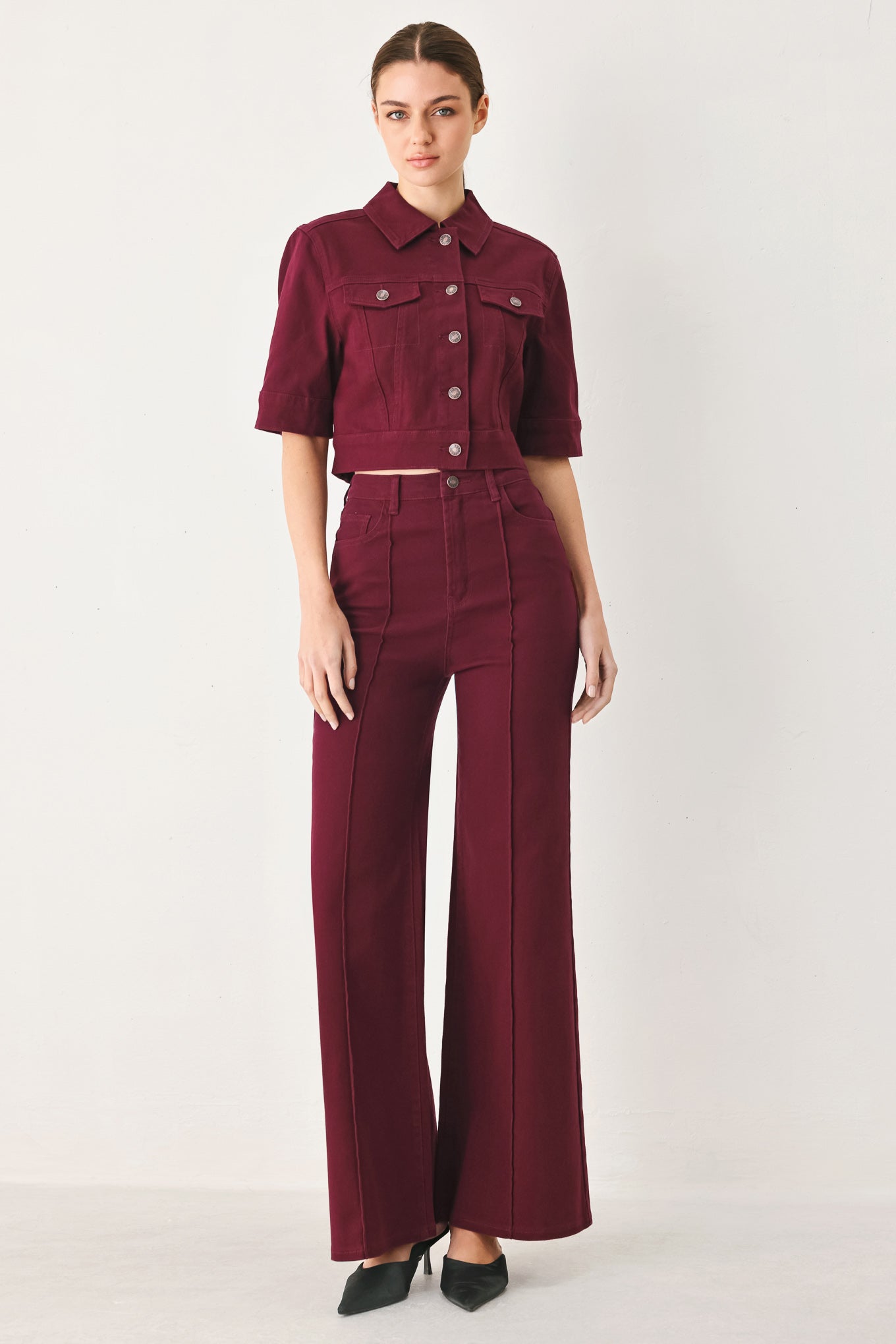 Woman wearing solid burgundy twill pants featuring front closure, front seam in the middle of each leg and pockets | FREEMARKET