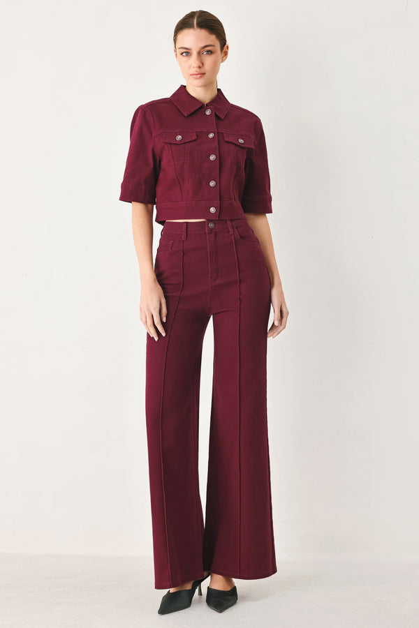Woman wearing solid burgundy twill pants featuring front closure, front seam in the middle of each leg and pockets | FREEMARKET