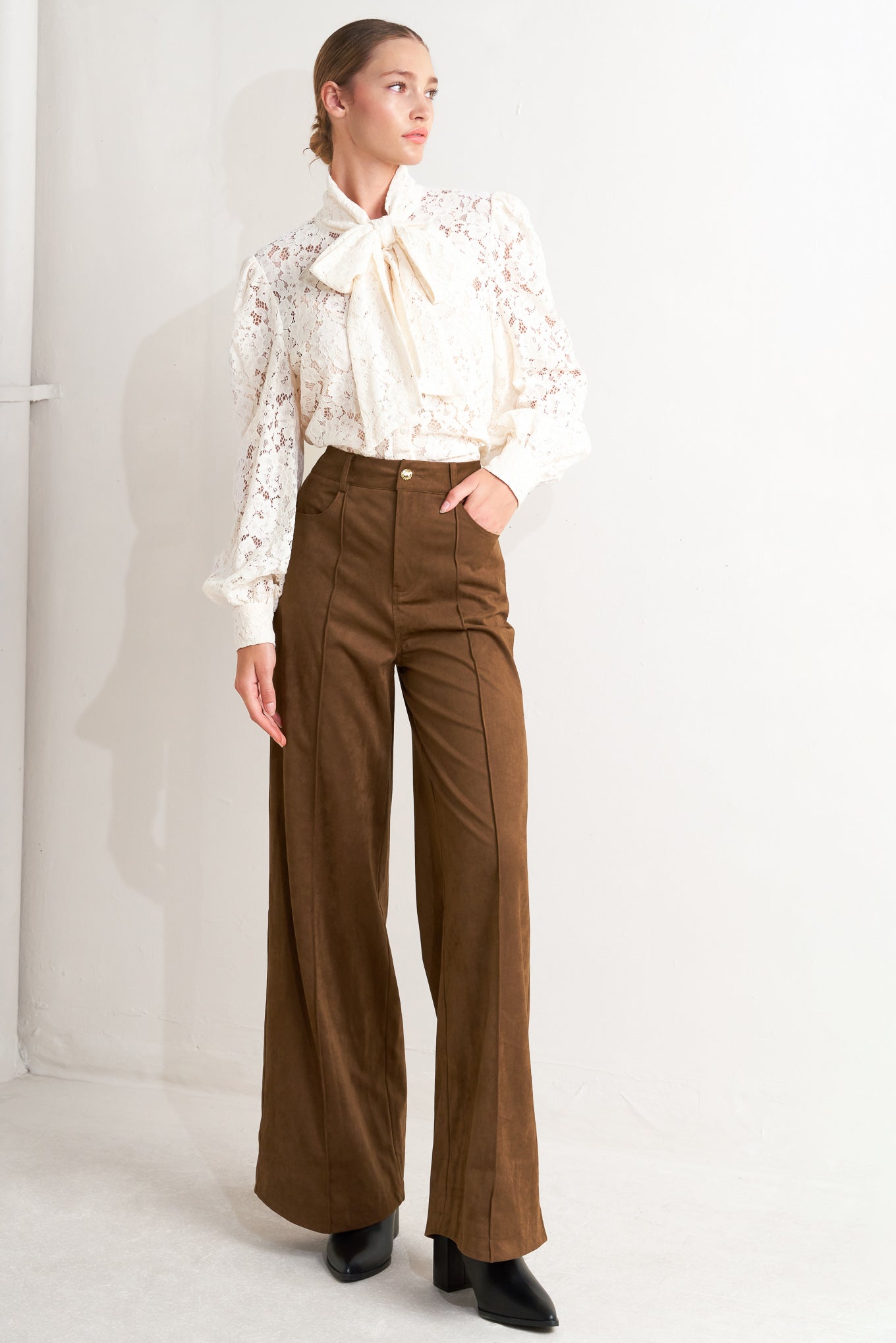 A faux suede pant featuring side and back pocket, front closure and flare leg.