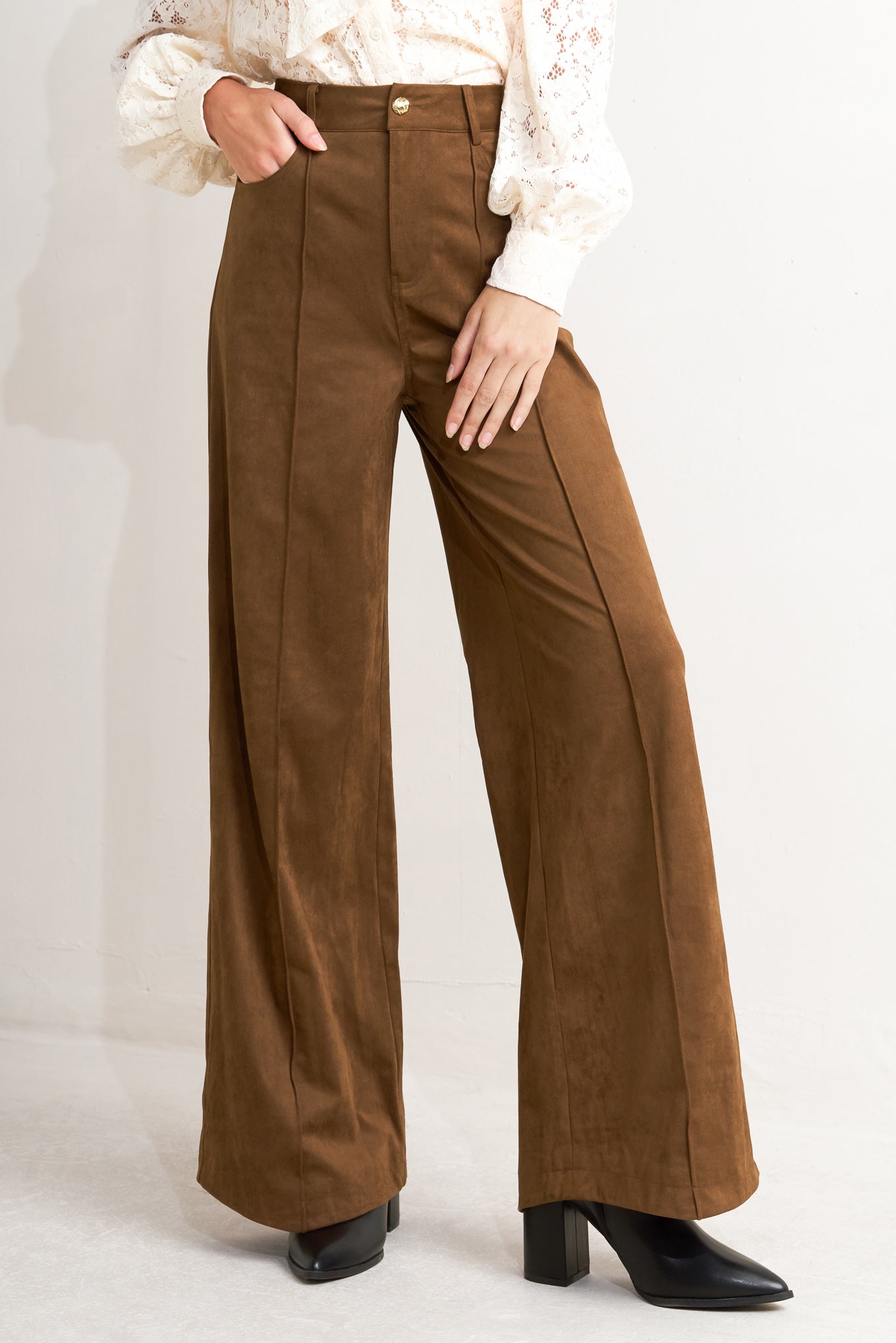 A faux suede pant featuring side and back pocket, front closure and flare leg.