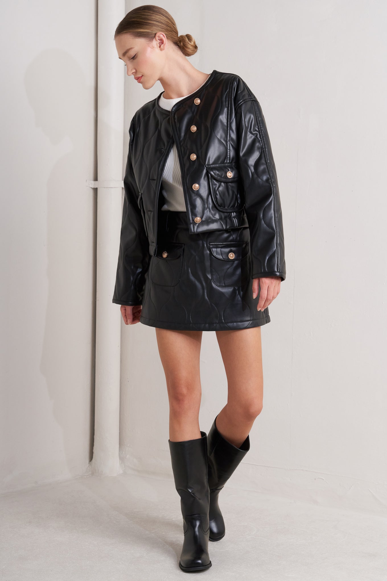 A quilted faux leather skort featuring front pockets and back zipper closure.