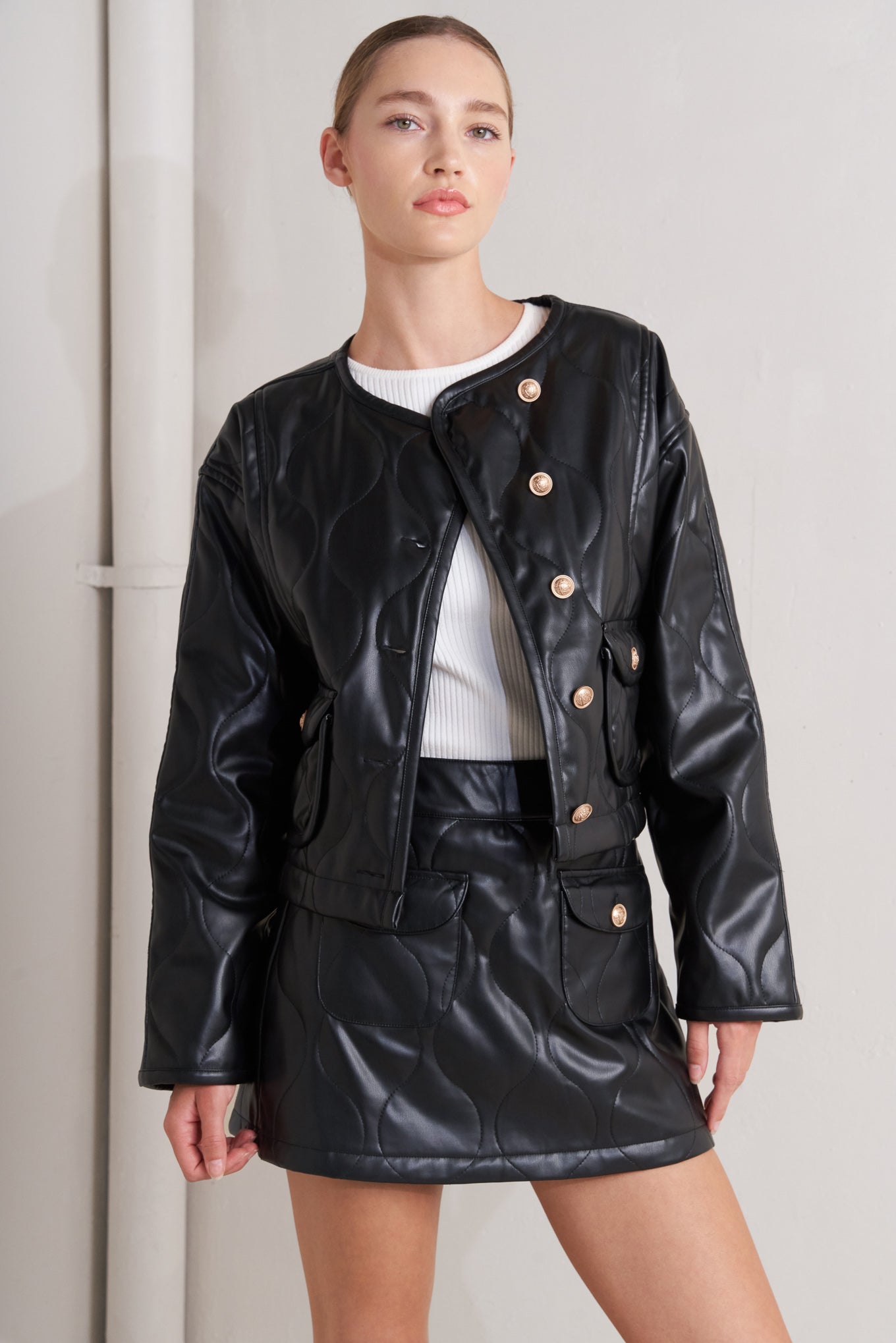 A quilted faux leather skort featuring front pockets and back zipper closure.