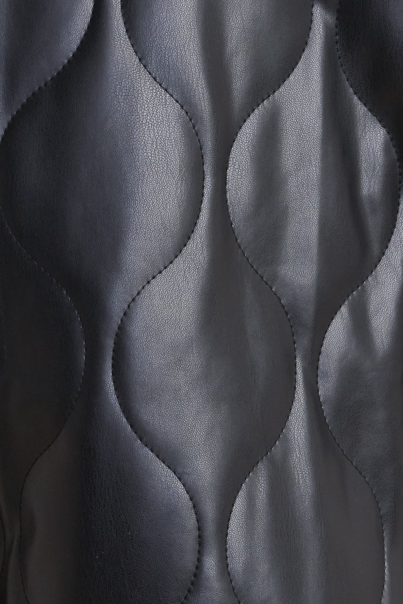 A quilted faux leather skort featuring front pockets and back zipper closure.