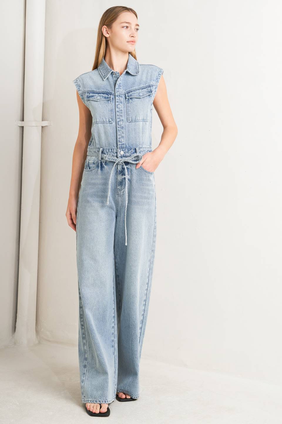 A washed denim jumpsuit featuring collar, hidden button down and zipper closure, cap sleeve, pockets, self tie and wide leg - Flying Tomato