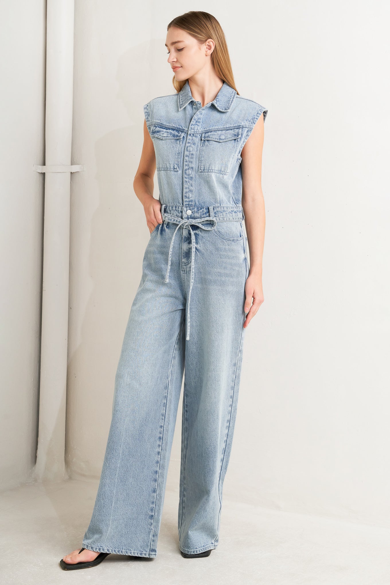 
A washed denim jumpsuit featuring collar, hidden button down and zipper closure, cap sleeve, pockets, self tie and wide leg

Details:

Self : 90% Cotton 10% Polyester

Size &amp; Fit

- Model is 5`8" And Wearing Size Small
- Measurements Taken From Size Small
- Approx. Length: 62"