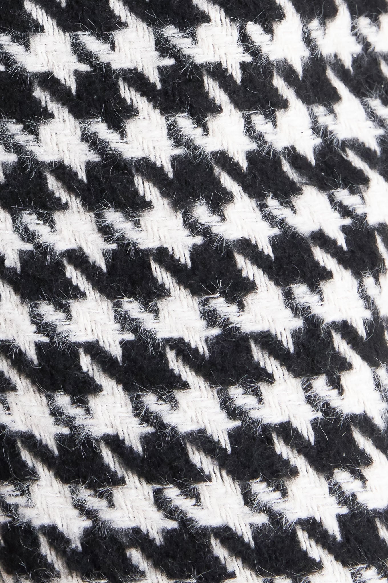 A woven houndstooth wide leg pant with side pockets with buttons and back zipper closure. 