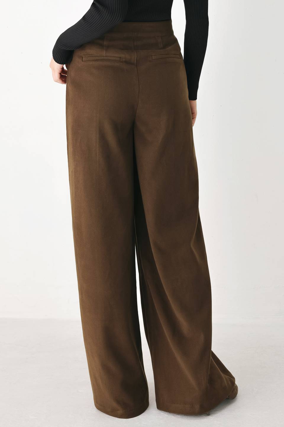 A model wearing high-waisted, wide-leg brown trousers with a corduroy-like texture | FREEMARKET