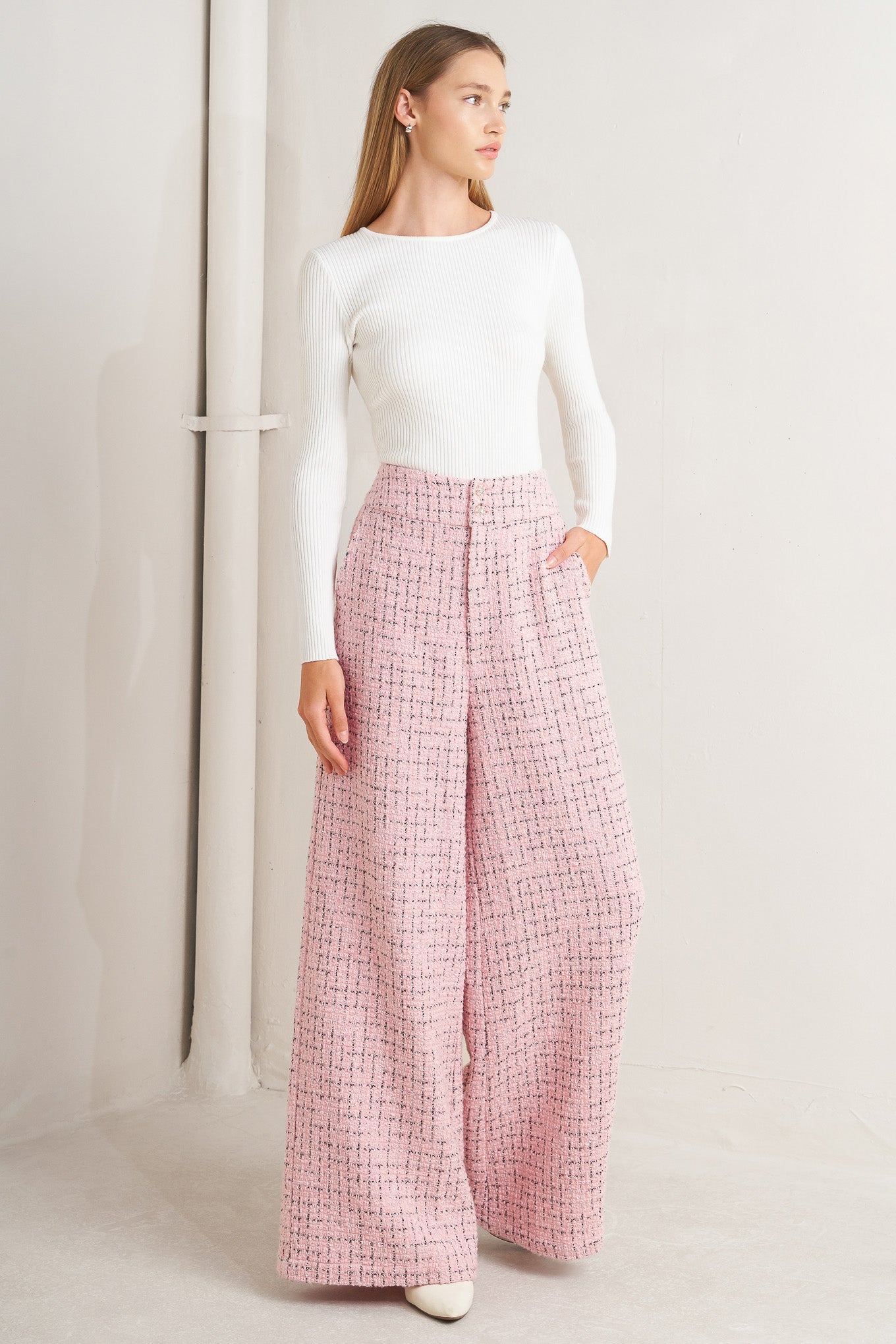 A tweed pant featuring front closure, pockets and wide leg.
