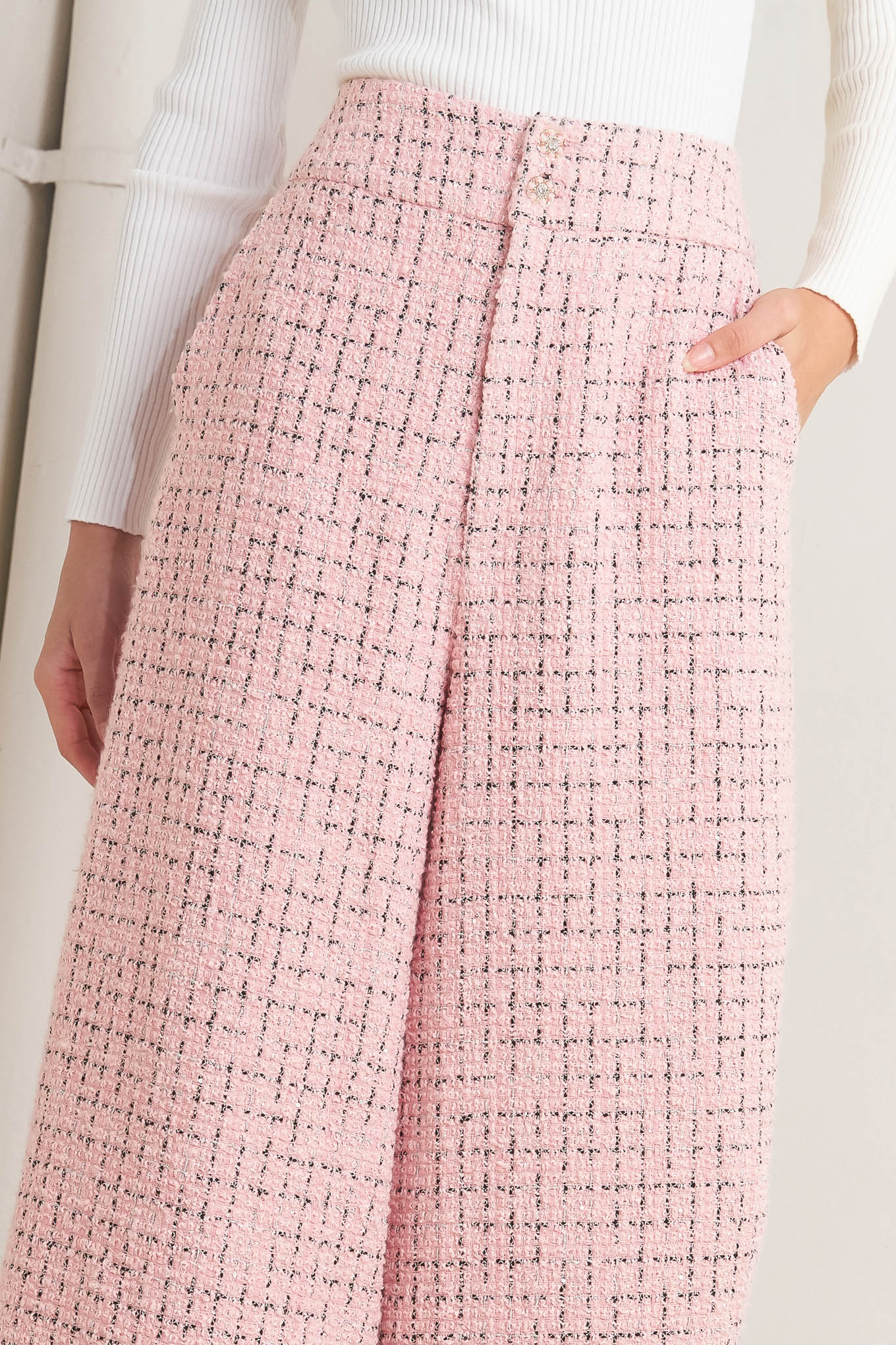 A tweed pant featuring front closure, pockets and wide leg.