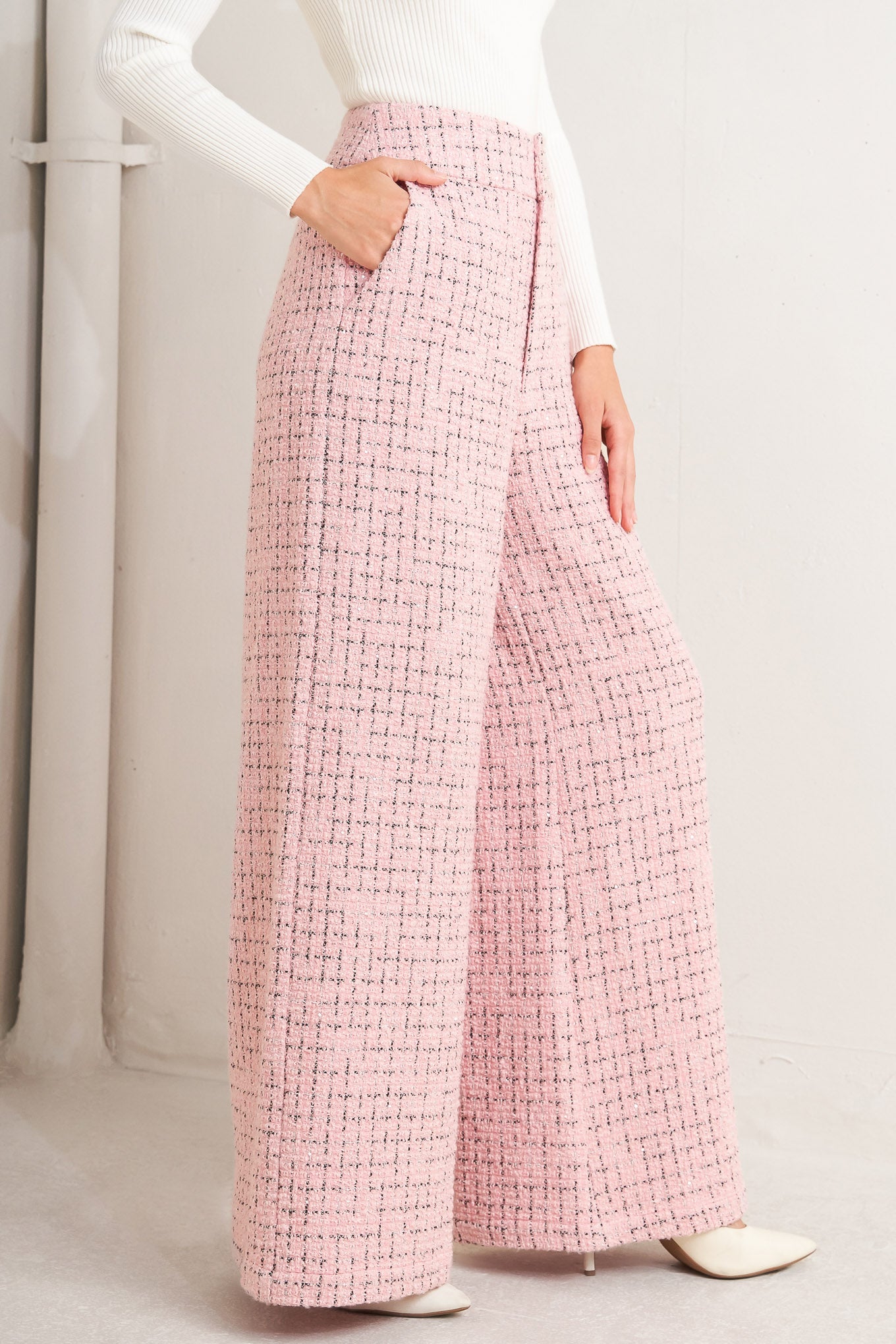 A tweed pant featuring front closure, pockets and wide leg.