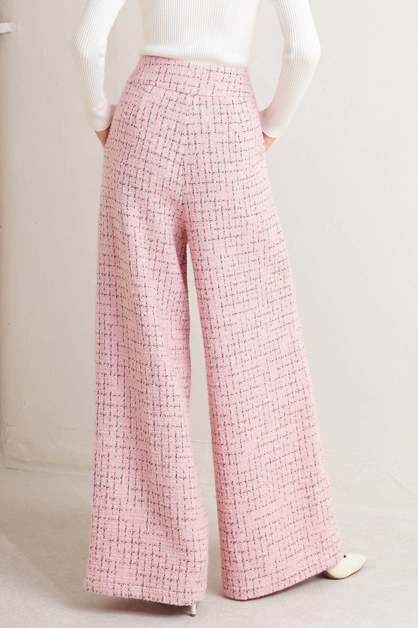A tweed pant featuring front closure, pockets and wide leg.