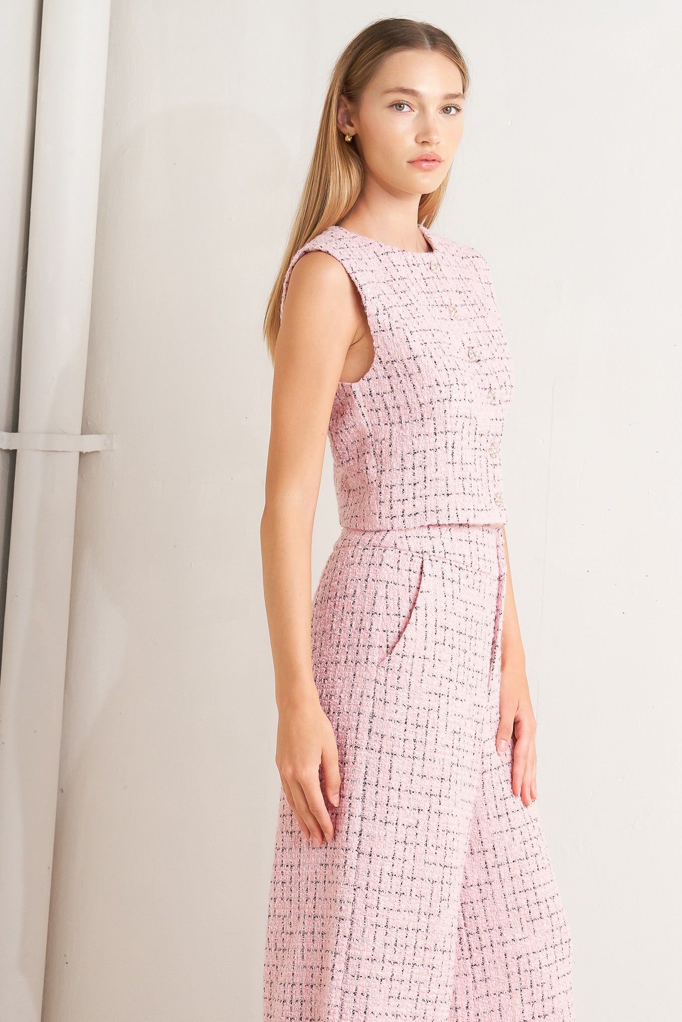 A tweed pant featuring front closure, pockets and wide leg.