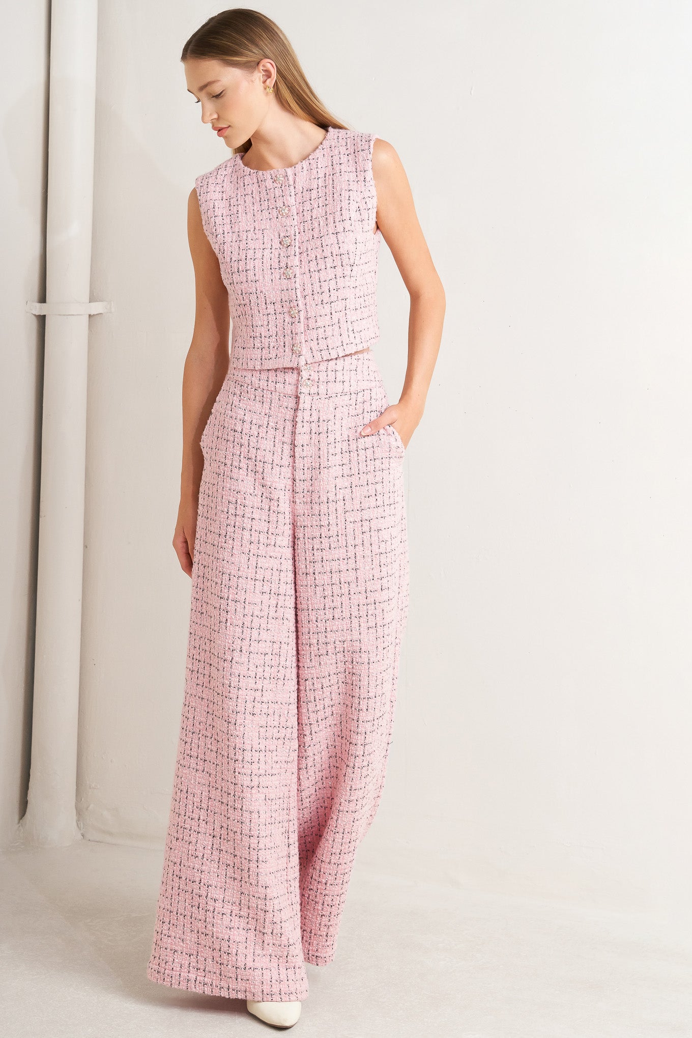 A tweed pant featuring front closure, pockets and wide leg.