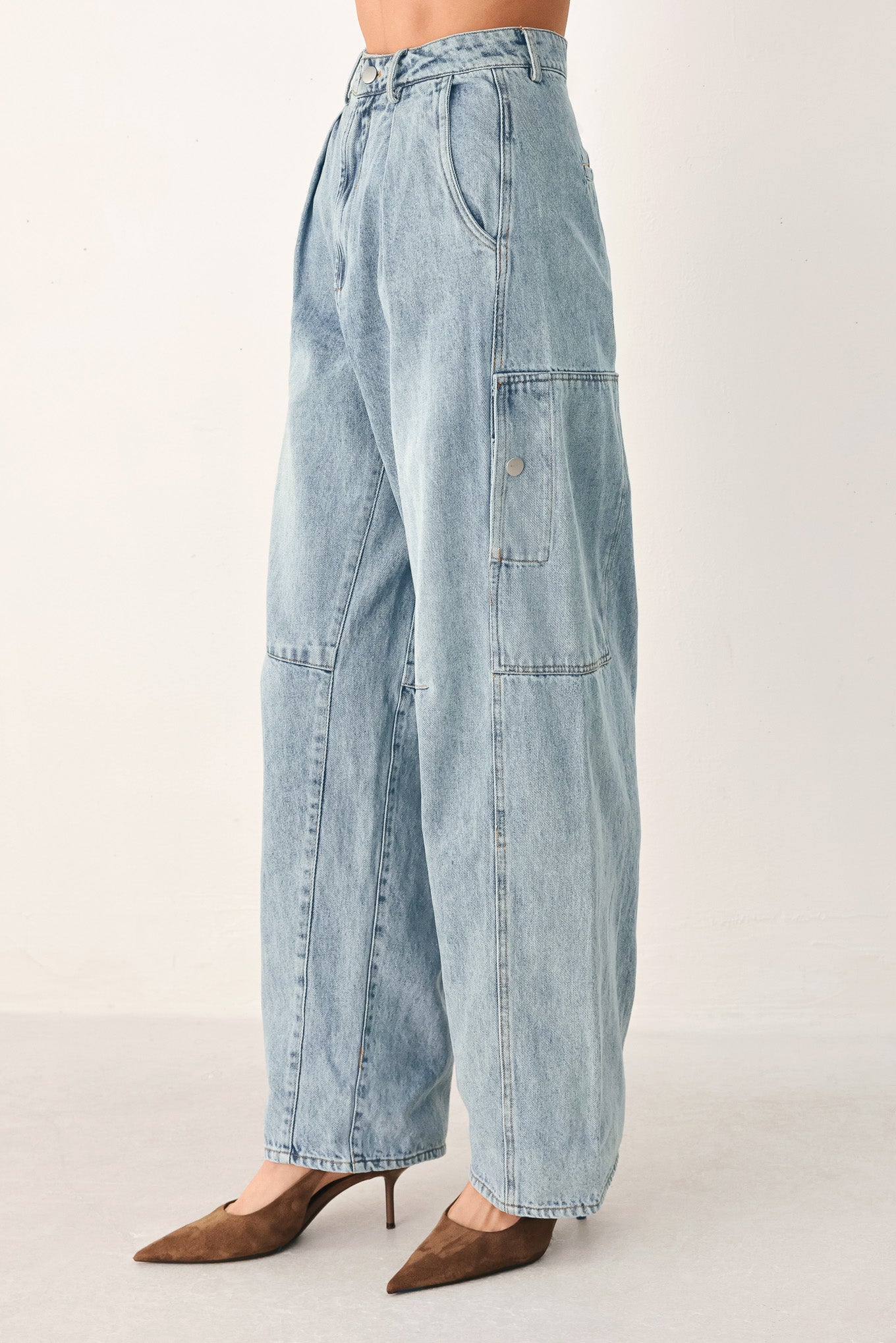 A person wearing light-wash blue denim jeans with a high waist, pleated front, and wide legs | FREEMARKET