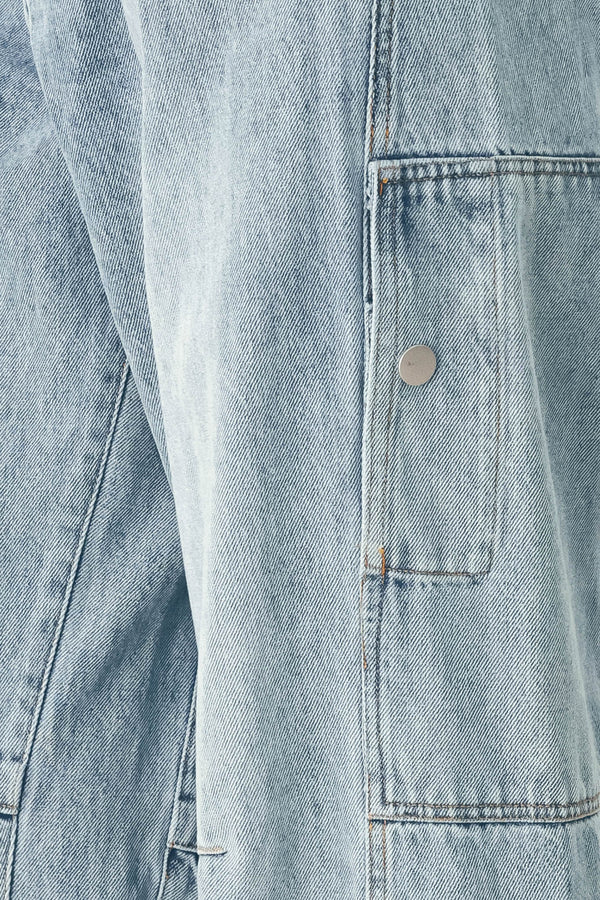 A person wearing light-wash blue denim jeans with a high waist, pleated front, and wide legs | FREEMARKET