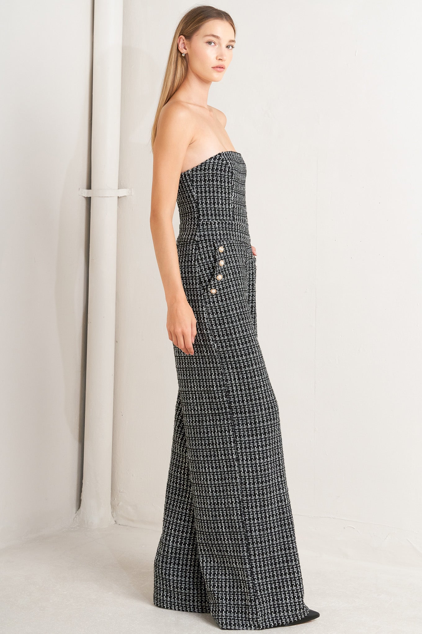 A tweed jumpsuit featuring strapless, side pockets with button detail, wide leg and back zipper closure