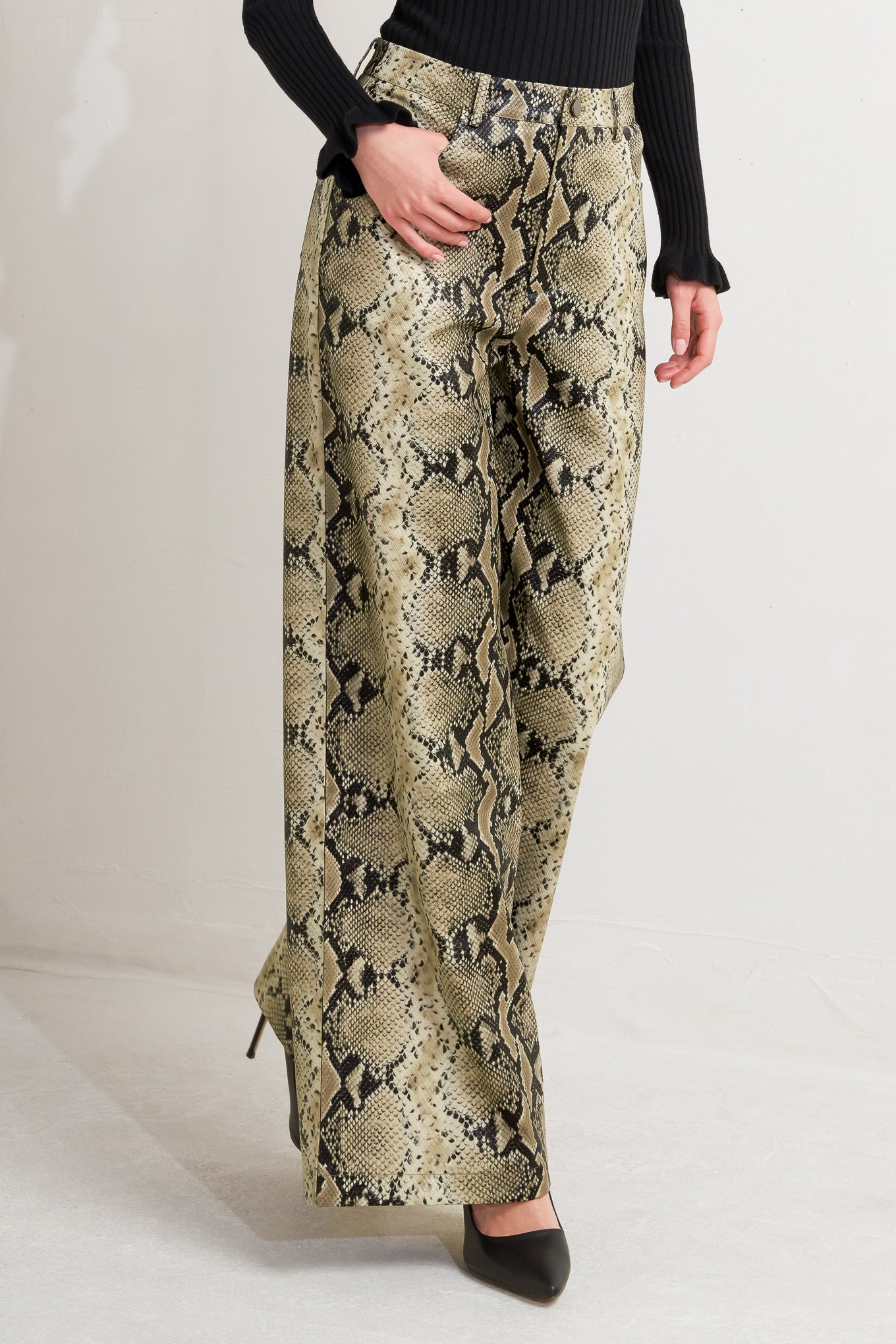 A printed faux leather pant with front closure, side pockets, and wide leg