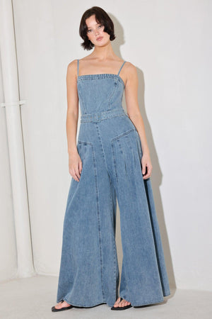 
A washed denim jumpsuit featuring straight neckline, straps, self belt, extra wide leg and back zipper closure

Details:

Self : 90.2% Cotton 4.8% Viscose 5% Polyester

Size &amp; Fit

- Model is 5`8" And Wearing Size Small
- Measurements Taken From Size Small
- Approx. Length: 60"
