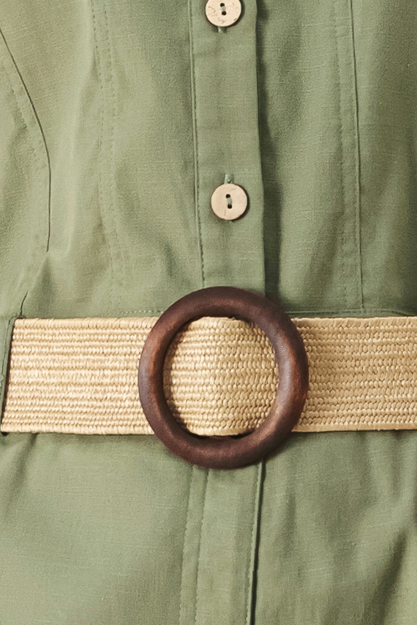 A solid woven romper featuring collar, sleeveless, front button zipper closure, pockets, cuffed hem and contrasting belt