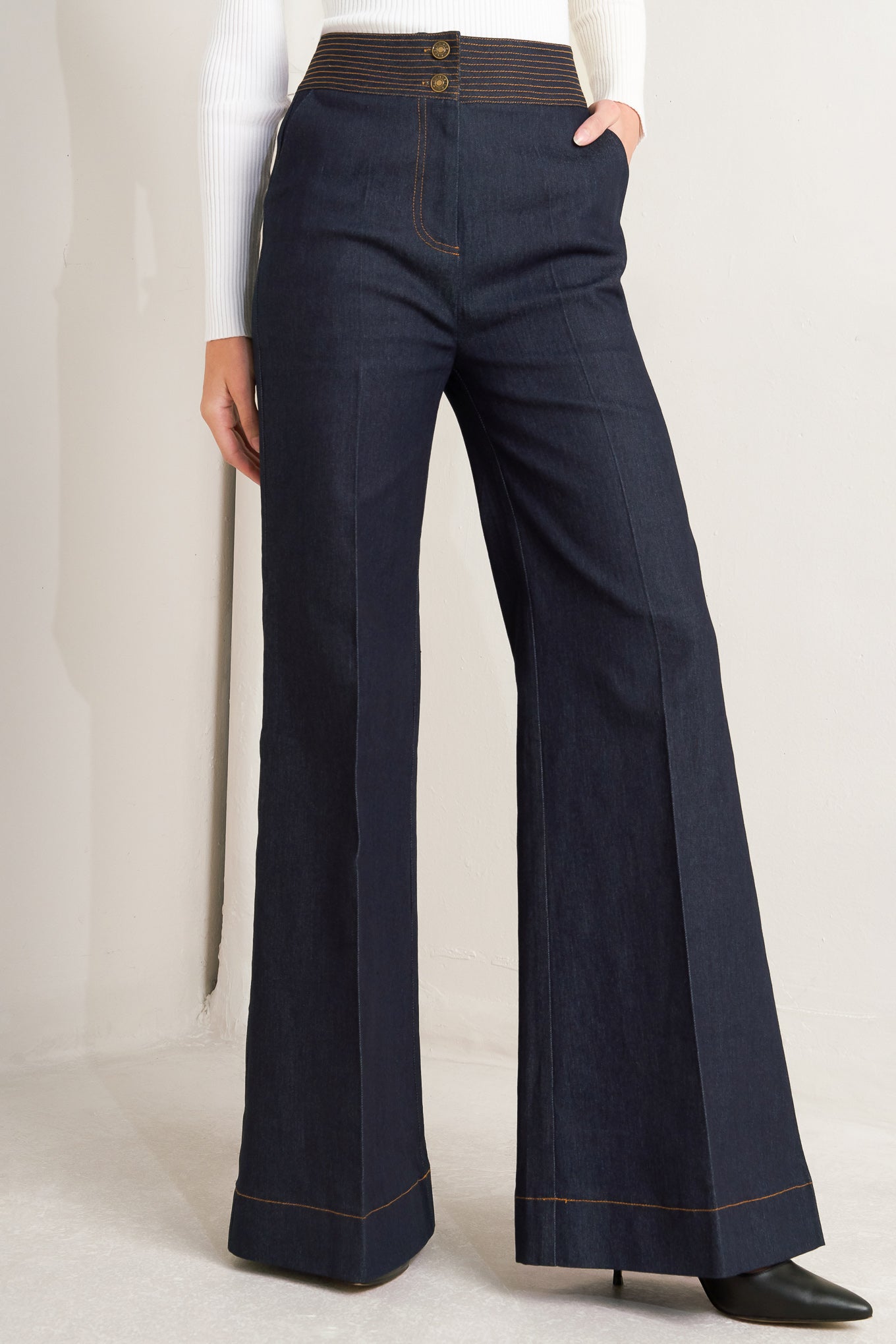 A denim pant featuring front closure, wide waistband with stitching detail, side pocket and wide leg.
